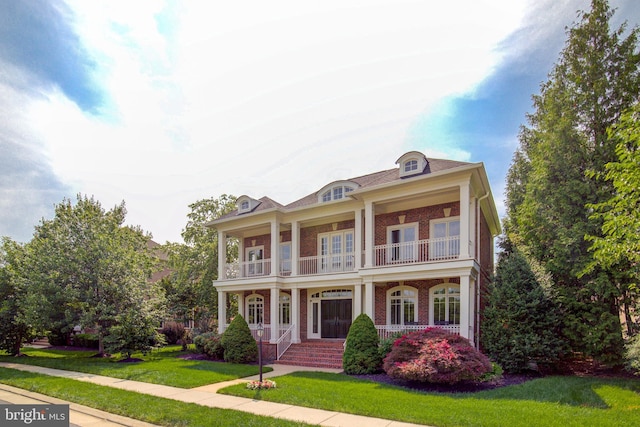 22966 Lois, Brambleton, VA 20148 - view of front of property with a balcony, a porch, brick siding, and a front lawn