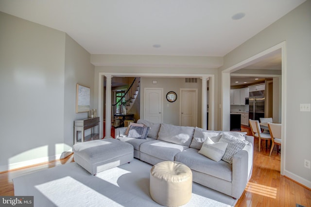 22966 Lois, Brambleton, VA 20148 - living area with stairway, light wood finished floors, and ornate columns