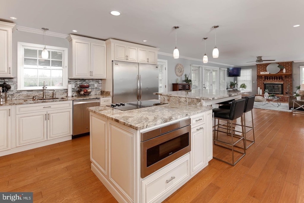 2801 Glen Keld Ct, Baldwin, MD 21013 - kitchen featuring stainless steel appliances, crown molding, open floor plan, a fireplace, and ceiling fan