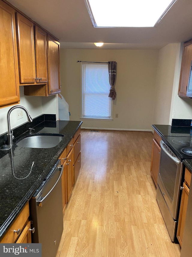 14004 Daleshire Way Unit 49, Burtonsville, MD 20866 - kitchen featuring appliances with stainless steel finishes, light wood-style flooring, brown cabinets, and dark stone counters