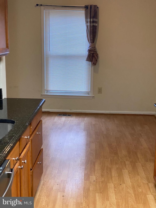14004 Daleshire Way Unit 49, Burtonsville, MD 20866 - kitchen with light wood-style flooring, brown cabinetry, and dark stone countertops