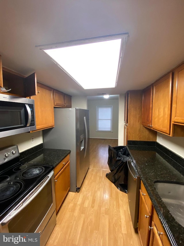 14004 Daleshire Way Unit 49, Burtonsville, MD 20866 - kitchen with stainless steel appliances, brown cabinetry, light wood-type flooring, and dark stone counters