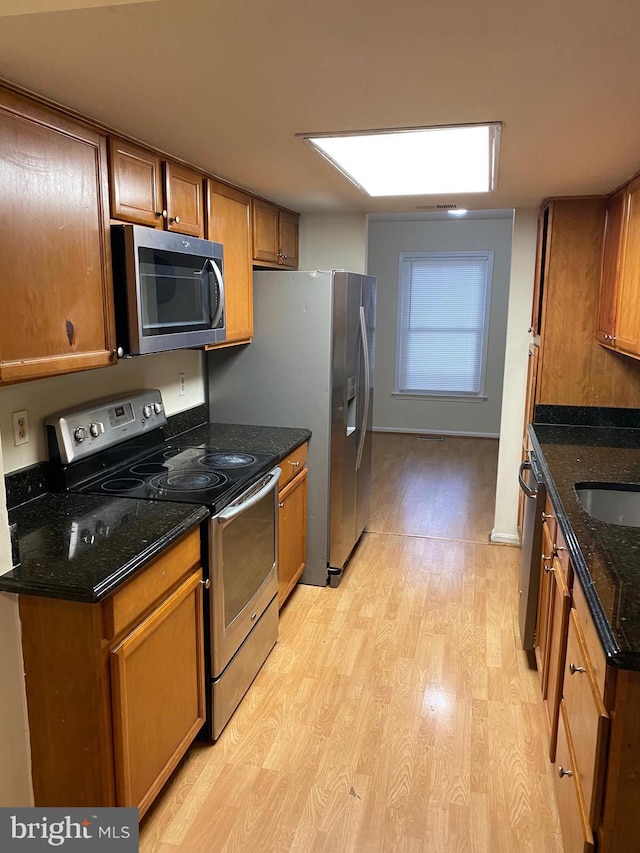 14004 Daleshire Way Unit 49, Burtonsville, MD 20866 - kitchen featuring stainless steel appliances, light wood-type flooring, brown cabinets, and dark stone countertops