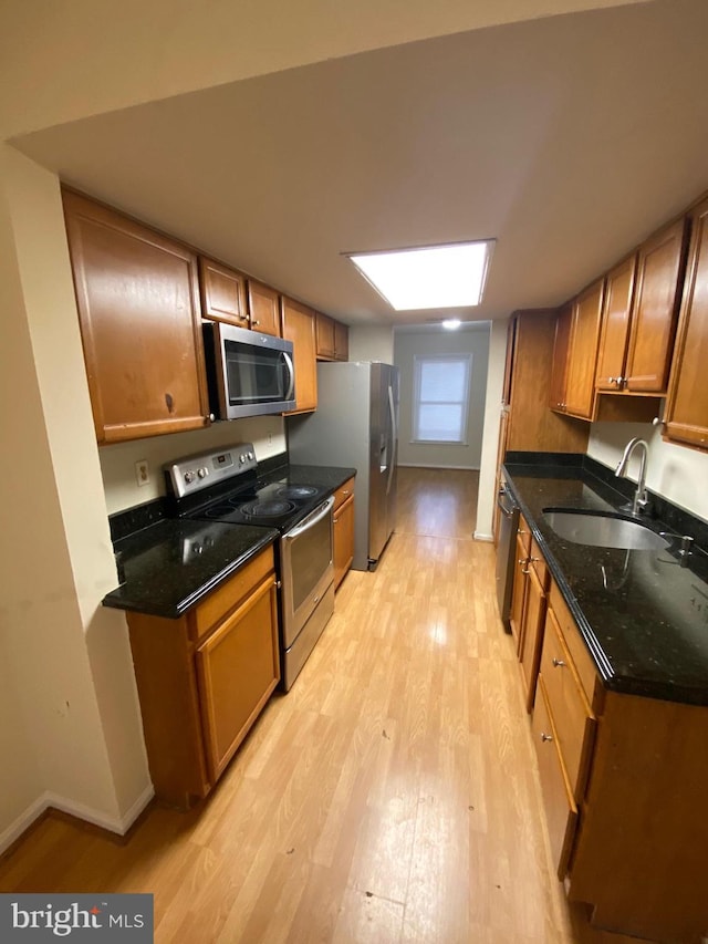 14004 Daleshire Way Unit 49, Burtonsville, MD 20866 - kitchen featuring appliances with stainless steel finishes, light wood-style floors, dark stone countertops, and brown cabinets