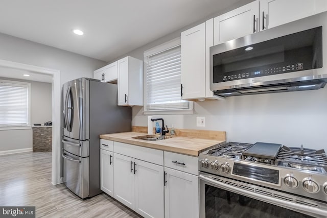 7135 Railway, Dundalk, MD 21222 - kitchen with appliances with stainless steel finishes, wood counters, light wood-style floors, white cabinetry, and healthy amount of natural light