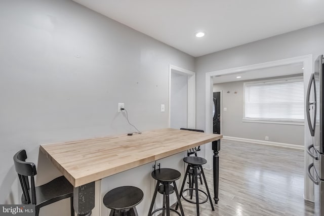 7135 Railway, Dundalk, MD 21222 - kitchen featuring wooden counters, a breakfast bar, freestanding refrigerator, light wood-style flooring, and recessed lighting