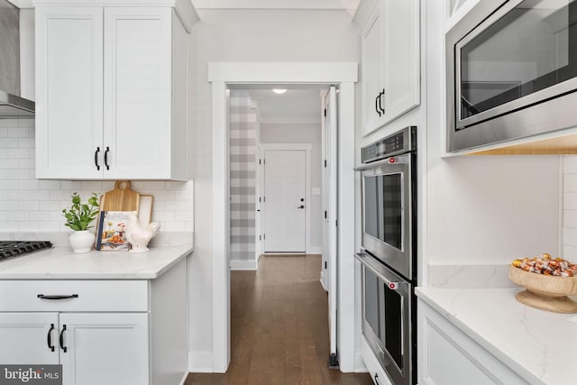115 Saddle Ridge Ln, Fredericksburg, VA 22406 - kitchen featuring appliances with stainless steel finishes, wall chimney exhaust hood, white cabinets, decorative backsplash, and crown molding