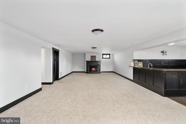 115 Saddle Ridge Ln, Fredericksburg, VA 22406 - unfurnished living room featuring light colored carpet, a warm lit fireplace, and bar