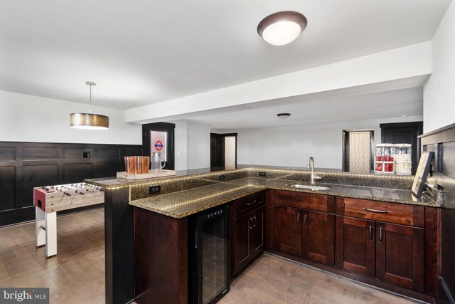 115 Saddle Ridge Ln, Fredericksburg, VA 22406 - kitchen with wine cooler, dark wood-type flooring, dark stone counters, a wainscoted wall, and pendant lighting