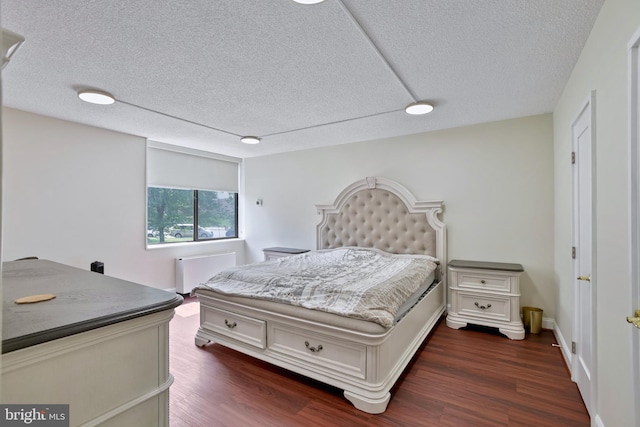 3701 S George Mason Dr Unit 205N, Falls Church, VA 22041 - bedroom featuring a textured ceiling, radiator, and dark wood-style floors