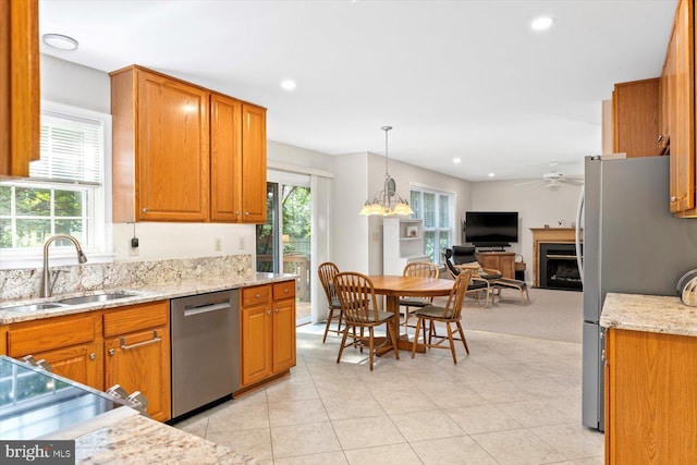 10 Frantz Ct, Fredericksburg, VA 22405 - kitchen with appliances with stainless steel finishes, open floor plan, a ceiling fan, a fireplace, and brown cabinets
