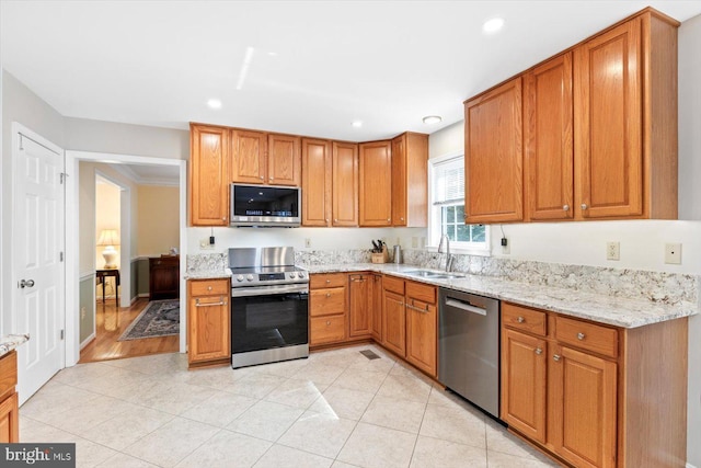 10 Frantz Ct, Fredericksburg, VA 22405 - kitchen with stainless steel appliances, light stone counters, recessed lighting, light tile patterned floors, and brown cabinetry