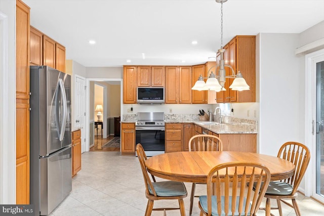10 Frantz Ct, Fredericksburg, VA 22405 - kitchen with appliances with stainless steel finishes, light tile patterned floors, recessed lighting, brown cabinetry, and decorative light fixtures