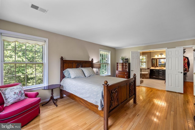 9100 Quarter Ct, Vienna, VA 22182 - bedroom with light wood-style flooring, ensuite bathroom, bar, and ornamental molding