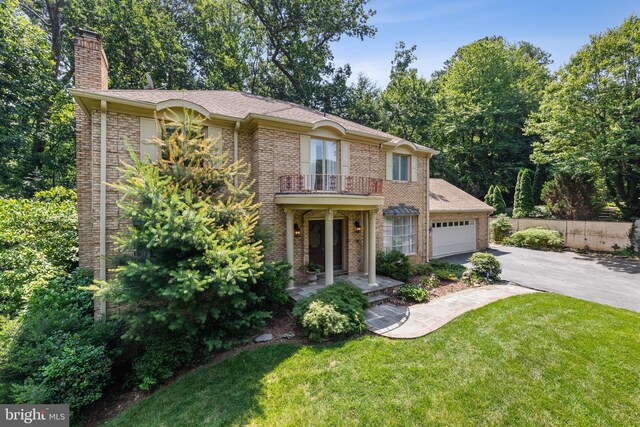9100 Quarter Ct, Vienna, VA 22182 - view of front of house featuring a balcony, driveway, a chimney, an attached garage, and brick siding