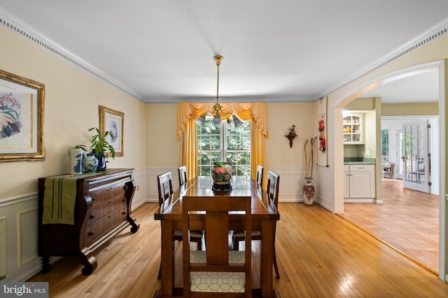 9100 Quarter Ct, Vienna, VA 22182 - dining area featuring arched walkways, plenty of natural light, a chandelier, wainscoting, and light wood-type flooring