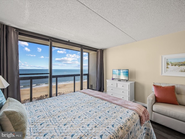 10900 Coastal Hwy Unit 814Golden, Sands, Ocean City, MD 21842 - bedroom with a textured ceiling, a wall of windows, and wood finished floors