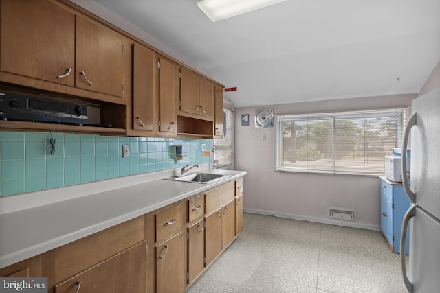 64 Warwick Rd, Stratford, NJ 08084 - kitchen with freestanding refrigerator, light flooring, light countertops, backsplash, and brown cabinetry
