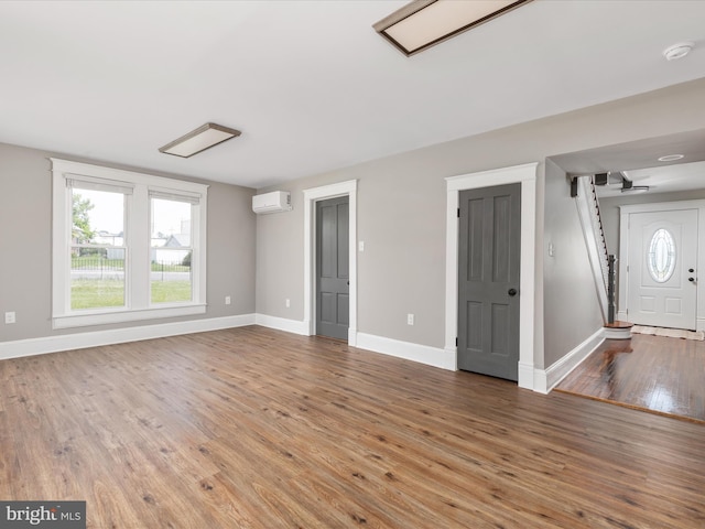 232 Crawford St, Strasburg, VA 22657 - unfurnished living room with an AC wall unit and wood finished floors