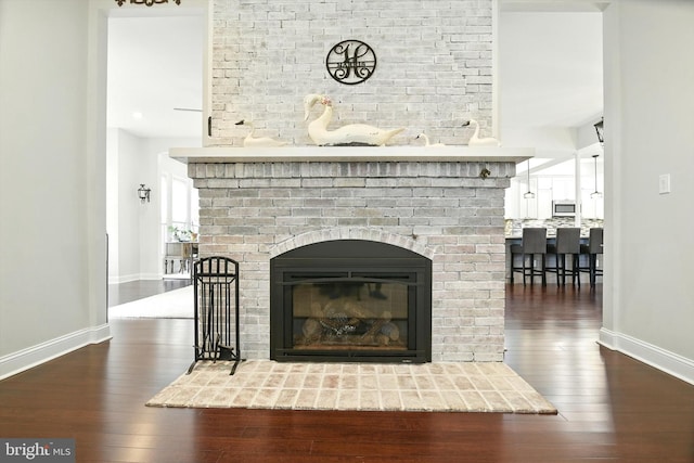 110 S Washington St, Havre De Grace, MD 21078 - detailed view of wood finished floors, a brick fireplace, and stainless steel microwave
