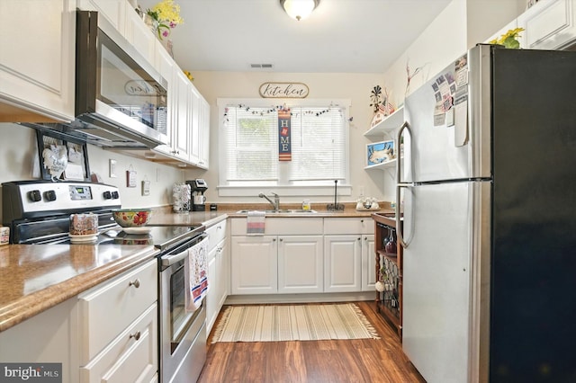 110 S Washington St, Havre De Grace, MD 21078 - kitchen with stainless steel appliances, white cabinets, dark wood-style flooring, and light countertops