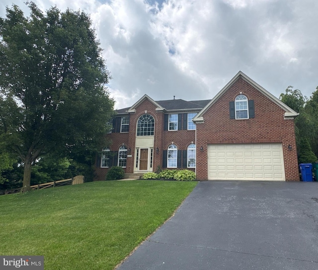 609 Corsair Ct, Sykesville, MD 21784 - view of front of home with driveway, a garage, brick siding, and a front lawn