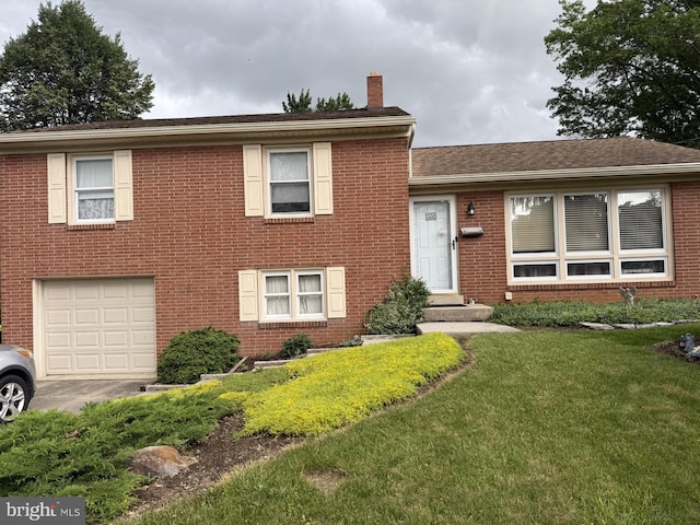 1002 S 2nd Ave, Lebanon, PA 17042 - tri-level home with an attached garage, a chimney, brick siding, a front lawn, and roof with shingles