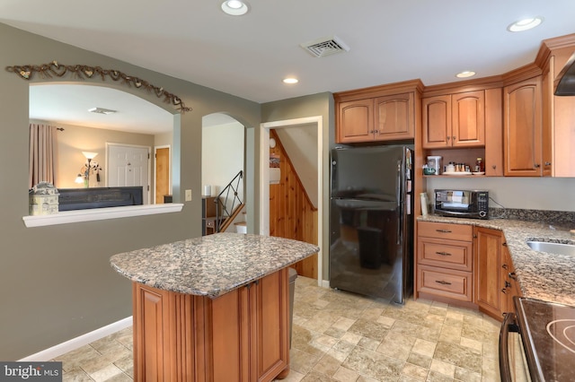 1002 S 2nd Ave, Lebanon, PA 17042 - kitchen featuring black appliances, arched walkways, stone finish flooring, light stone counters, and recessed lighting