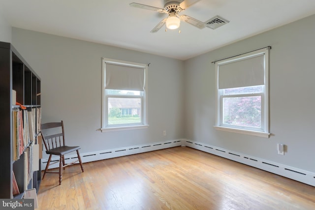 1002 S 2nd Ave, Lebanon, PA 17042 - empty room with plenty of natural light, light wood finished floors, a ceiling fan, and a baseboard heating unit