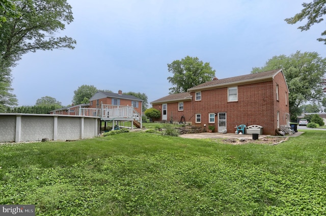 1002 S 2nd Ave, Lebanon, PA 17042 - rear view of house with brick siding, a yard, a swimming pool, a patio area, and a deck