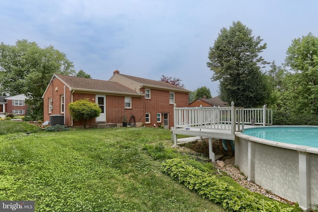 1002 S 2nd Ave, Lebanon, PA 17042 - back of property with brick siding, a deck, an outdoor pool, and a yard