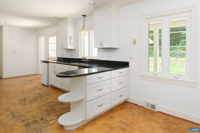 906 Old Farm Rd, Charlottesville, VA 22903 - kitchen with healthy amount of natural light, white cabinets, dark countertops, and a peninsula