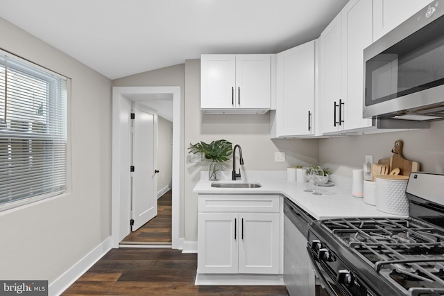 1510 Ramsay St, Baltimore, MD 21223 - kitchen featuring stainless steel appliances, light countertops, white cabinets, dark wood-type flooring, and vaulted ceiling