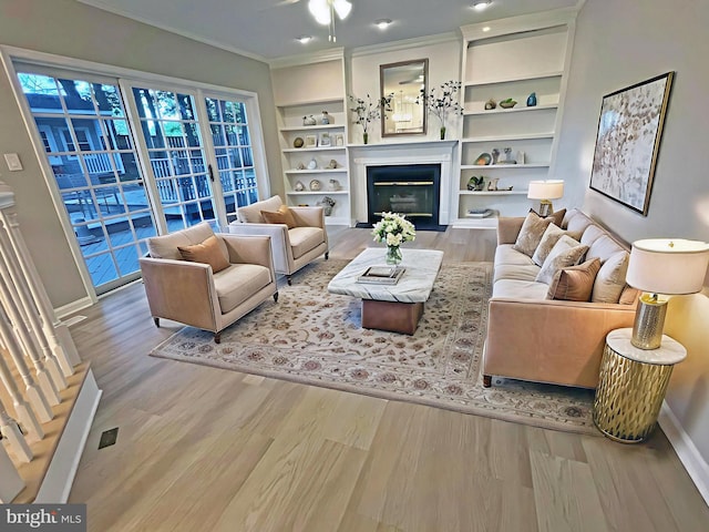 2510 Heatherwood Ct, Hyattsville, MD 20783 - living room with wood finished floors, a glass covered fireplace, crown molding, built in shelves, and ceiling fan