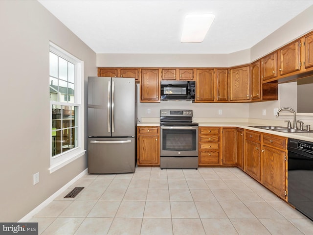 5220 Earles Ct, Frederick, MD 21703 - kitchen with black appliances, brown cabinetry, light countertops, and light tile patterned floors