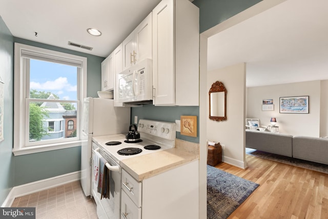 317 10th St NE Unit 13, Washington, DC 20002 - kitchen with white appliances, white cabinets, open floor plan, and light wood-style flooring