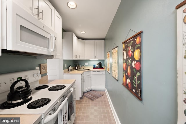 317 10th St NE Unit 13, Washington, DC 20002 - kitchen with white appliances, light countertops, white cabinets, recessed lighting, and light floors