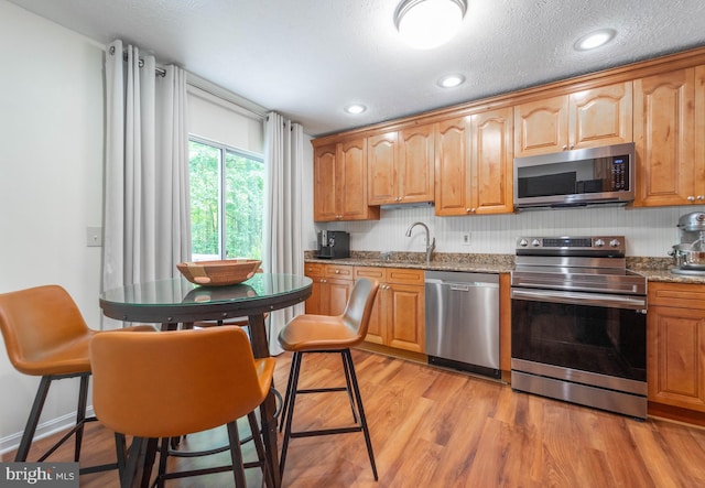 7781 Monaghan Rd, Glen Burnie, MD 21060 - kitchen featuring stainless steel appliances, light stone countertops, light wood-style flooring, and recessed lighting