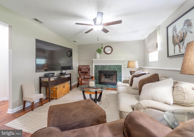 7781 Monaghan Rd, Glen Burnie, MD 21060 - living room with ceiling fan, a tiled fireplace, and wood finished floors