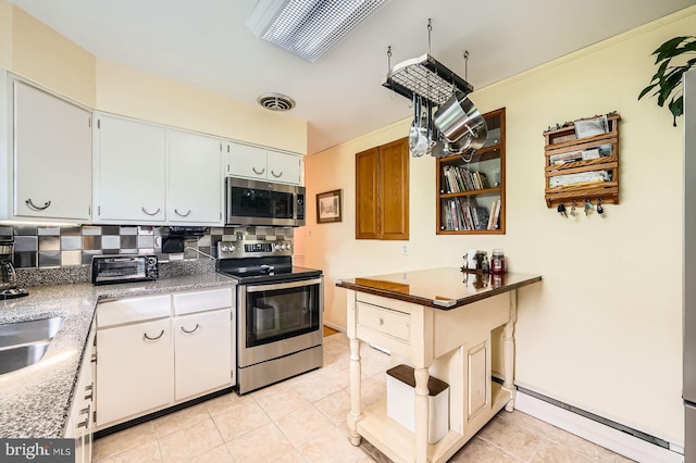 12105 Lanham Severn Rd, Bowie, MD 20720 - kitchen featuring appliances with stainless steel finishes, a baseboard radiator, tasteful backsplash, and light tile patterned flooring