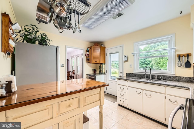 12105 Lanham Severn Rd, Bowie, MD 20720 - kitchen featuring fridge, light tile patterned floors, dark stone counters, and range