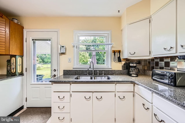 12105 Lanham Severn Rd, Bowie, MD 20720 - kitchen featuring white cabinets, dark stone counters, and decorative backsplash