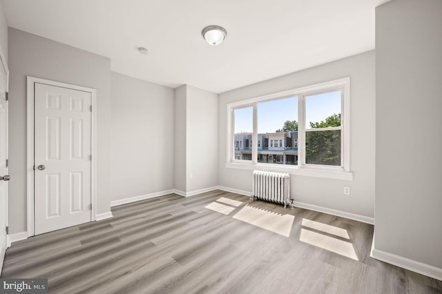 5242 Sylvester St, Philadelphia, PA 19124 - empty room featuring radiator, wood finished floors, and a smoke detector
