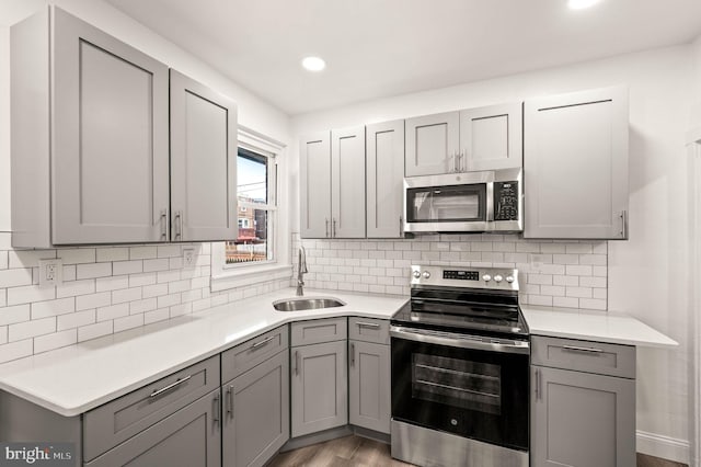 5242 Sylvester St, Philadelphia, PA 19124 - kitchen featuring appliances with stainless steel finishes, gray cabinets, light countertops, light wood-type flooring, and recessed lighting