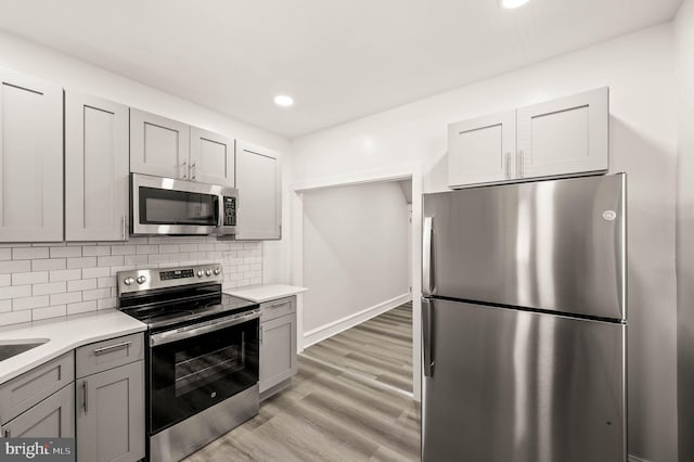 5242 Sylvester St, Philadelphia, PA 19124 - kitchen with appliances with stainless steel finishes, gray cabinetry, light countertops, light wood-type flooring, and recessed lighting