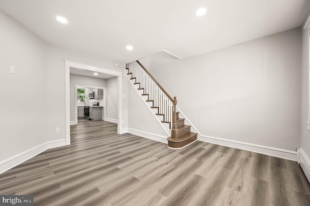 5242 Sylvester St, Philadelphia, PA 19124 - staircase with wood finished floors, recessed lighting, and a baseboard heating unit