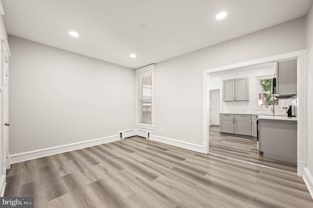 5242 Sylvester St, Philadelphia, PA 19124 - unfurnished living room with recessed lighting, light wood-style flooring, and a baseboard radiator