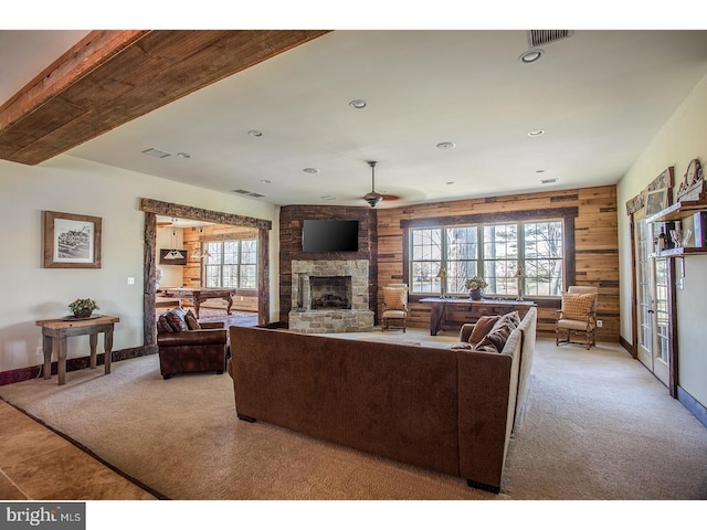2103 Street Rd, New Hope, PA 18938 - living area featuring carpet flooring, a stone fireplace, wooden walls, healthy amount of natural light, and ceiling fan