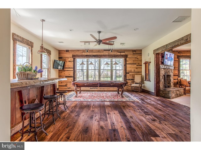 2103 Street Rd, New Hope, PA 18938 - dining area featuring wood walls, dark wood-style floors, ceiling fan, pool table, and a stone fireplace
