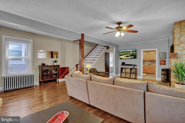 120 Hook St, Birdsboro, PA 19508 - living area featuring radiator, a textured ceiling, stairs, a ceiling fan, and wood finished floors